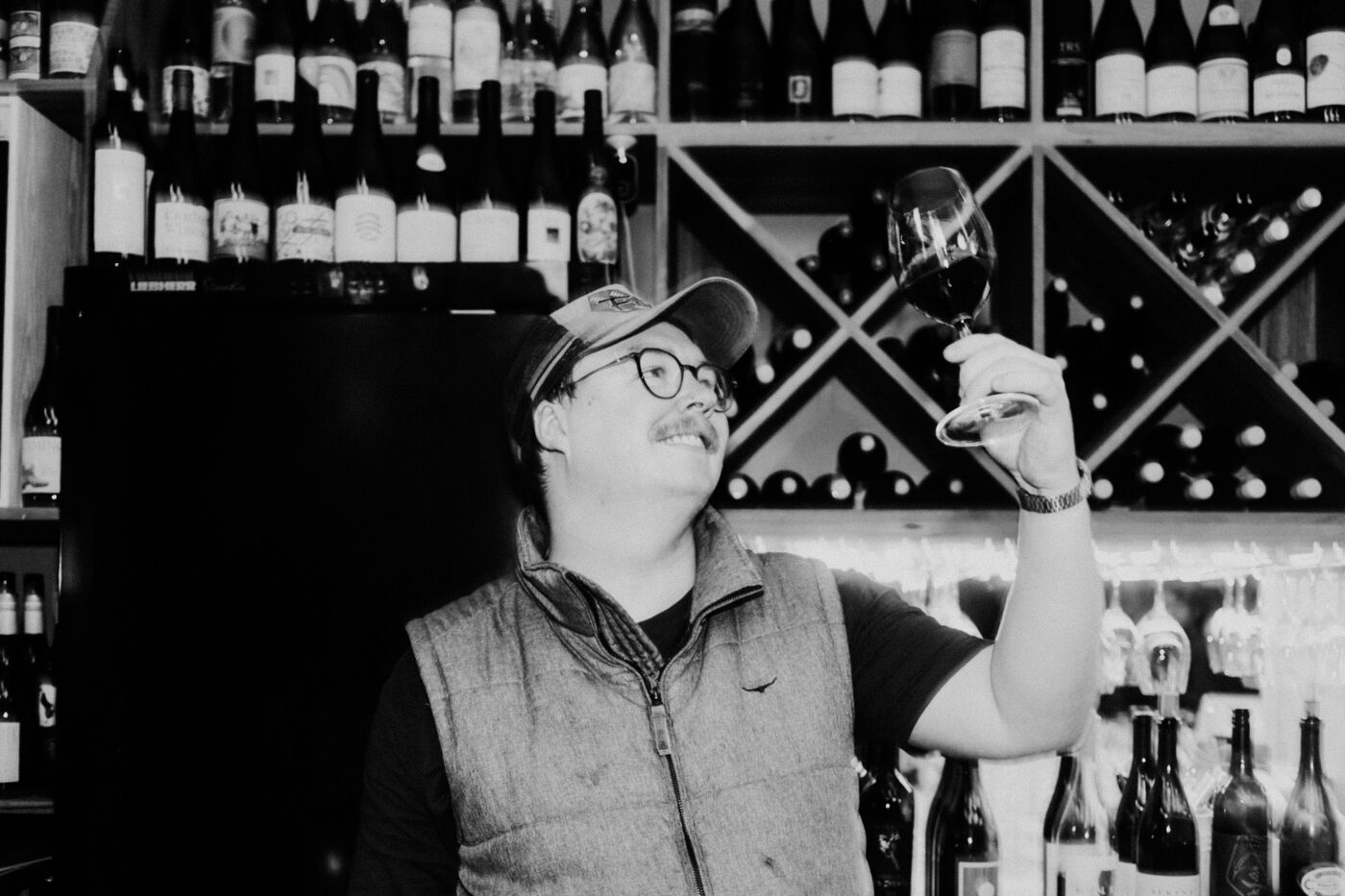 Edward Rava, Wine Director at Bar Septimus, assessing a glass in the cellar