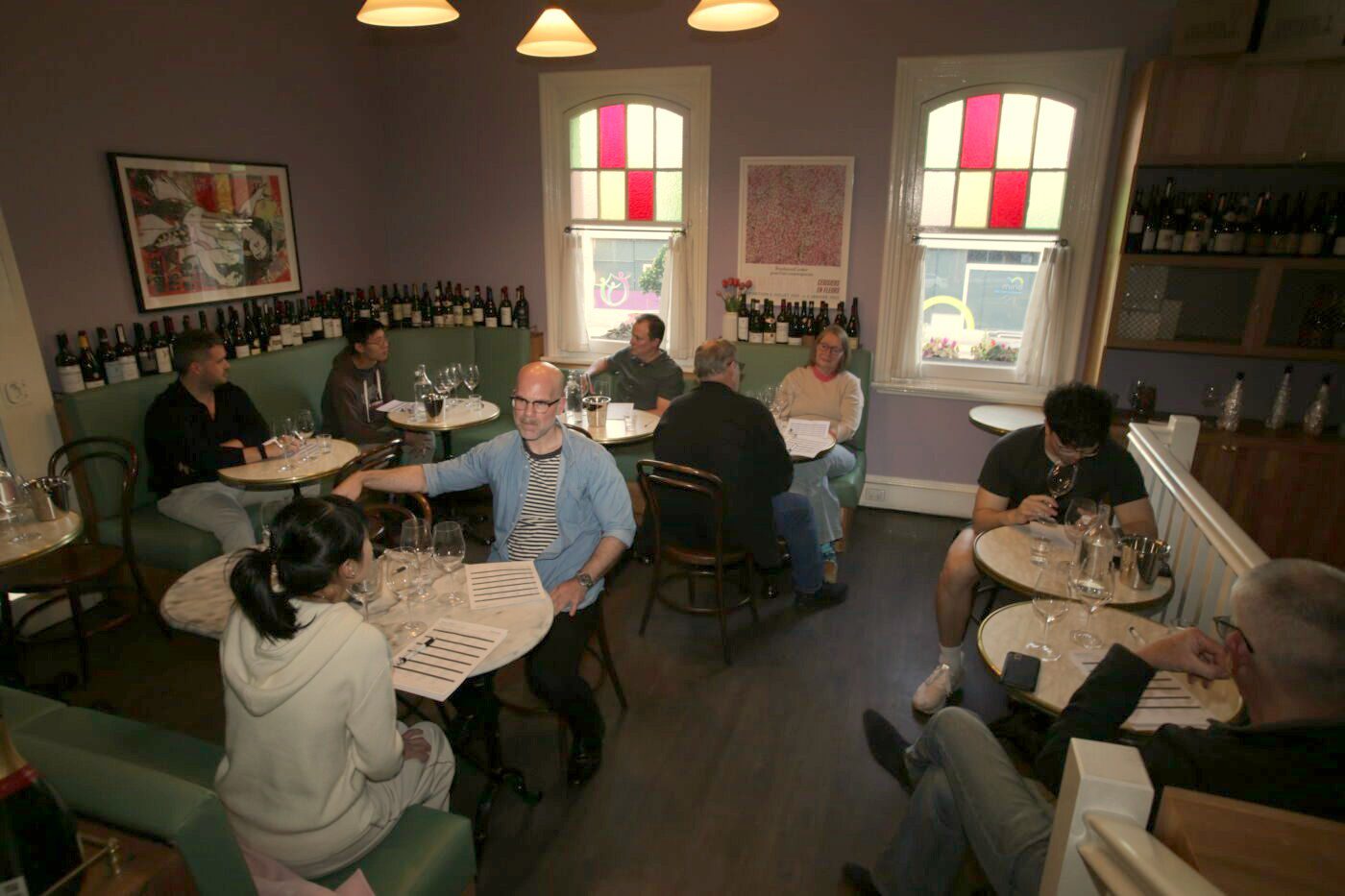 SAWOL Round 9: players at tables upstairs at Bar Septimus with answer sheets and six glasses each
