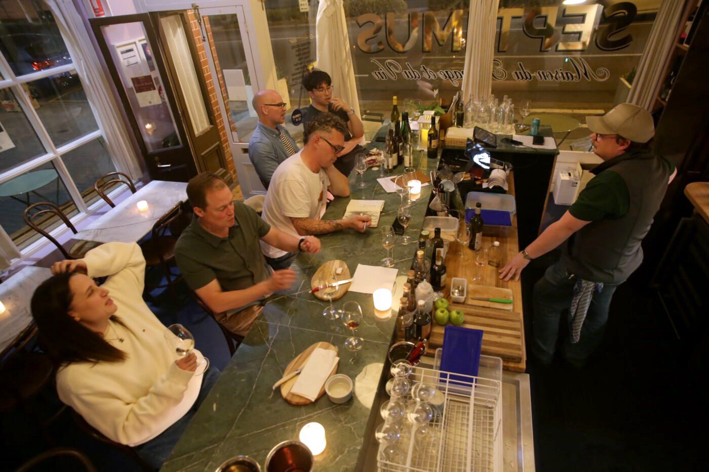 Guests in conversation along the counter at Bar Septimus